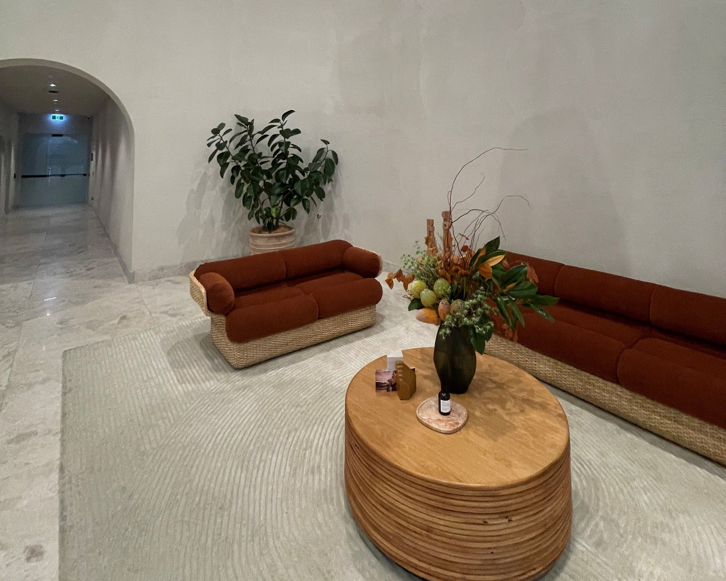 Modern living room with brown sofas, a wooden coffee table, and decorative items.