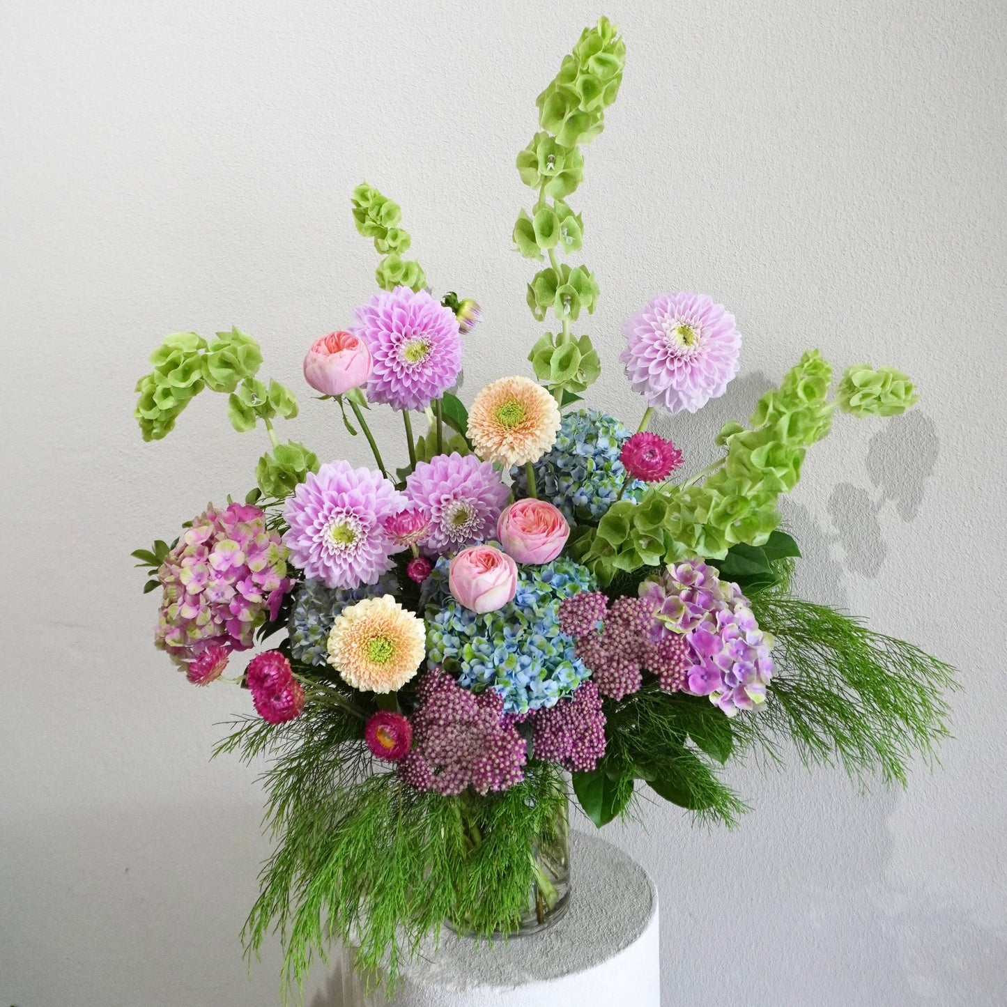 Colorful flower arrangement in a vase on a light gray background