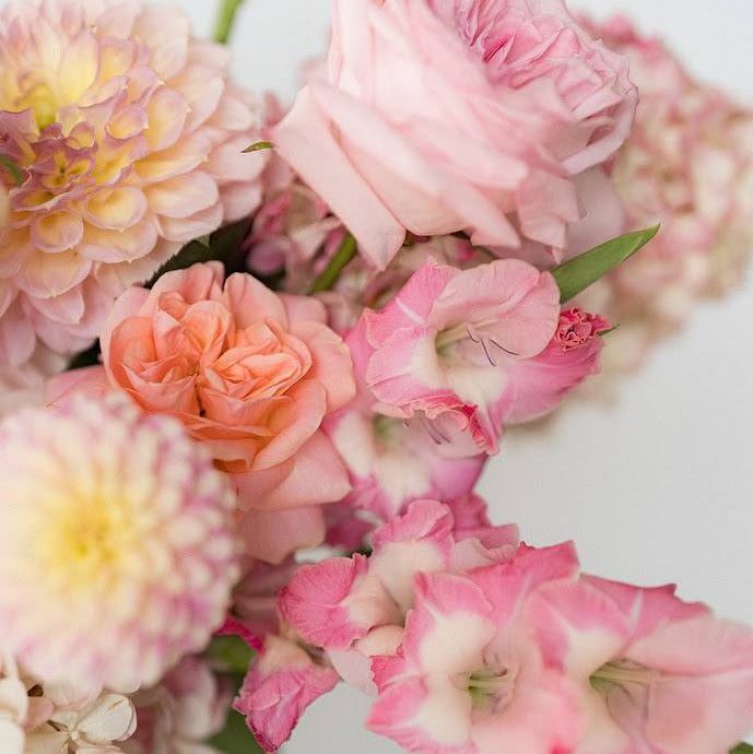 Close-up of a bouquet of pink and yellow flowers on a light background