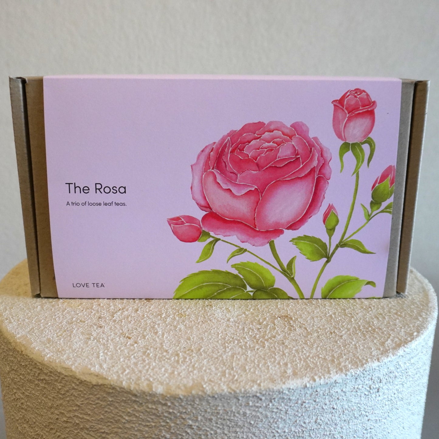 Tea box with pink rose design on a white background