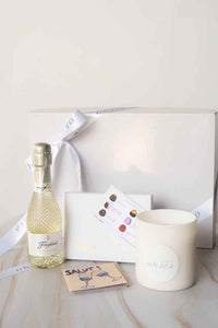 Bottle of Freixenet sparkling wine, a candle, and a card on a marble surface with a white background.