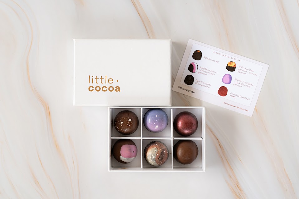 Box of Little Cocoa truffles on a marble surface