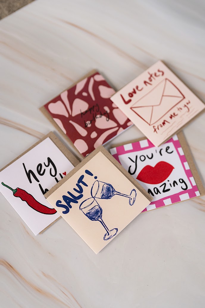 Collection of small greeting cards with various designs on a light surface