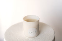 White candle with 'Studio Ohara' branding on a textured white surface