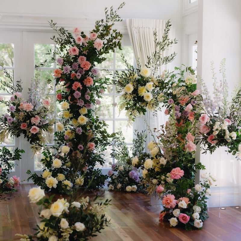 Decorative floral arches in a room with large windows.